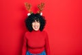 Young middle east woman wearing cute christmas reindeer horns winking looking at the camera with sexy expression, cheerful and Royalty Free Stock Photo