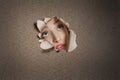 Young Middle eastern woman looking up from ripped paper hole Royalty Free Stock Photo