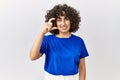 Young middle eastern woman standing over isolated background smiling and confident gesturing with hand doing small size sign with Royalty Free Stock Photo