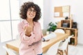 Young middle eastern woman wearing business style at office beckoning come here gesture with hand inviting welcoming happy and Royalty Free Stock Photo