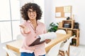 Young middle eastern woman wearing business style at office smiling cheerful offering palm hand giving assistance and acceptance Royalty Free Stock Photo