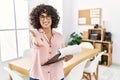 Young middle eastern woman wearing business style at office smiling friendly offering handshake as greeting and welcoming Royalty Free Stock Photo