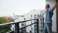 young millenial bold man morning strech on balcony - medium long space copy