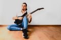 Young millenial man sitting on the floor of home playing an electric guitar Royalty Free Stock Photo