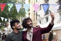 Young millennial biracial couple of happy males using mobile phone on the Barcelona city. Alternative style. Friendship Royalty Free Stock Photo