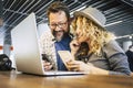 Young millennial couple working together in coworking space with mobile phones and laptop computer. Modern online job lifestyle Royalty Free Stock Photo