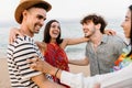 Young millennial friends laughing together enjoying summer vacation at the beach