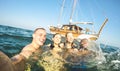 Young millennial friends taking selfie and swimming at sailing boat sea trip - Rich guys and girls having fun in summer party day Royalty Free Stock Photo