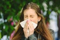 Young millennial sick woman sneeze holding tissue handkerchief and blowing wiping her running nose, concept seasonal allergy