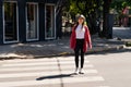 Young millennial woman crossing the street on the pedestrian path Royalty Free Stock Photo