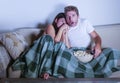 Young mixed race attractive couple with Asian Korean woman and white man enjoying together watching television horror movie scared Royalty Free Stock Photo