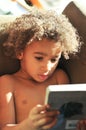 Young mixed race boy with curly hair reading Royalty Free Stock Photo