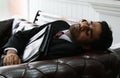 Young mixed-race business man sleeping on the couch. Royalty Free Stock Photo