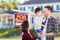 Young Mixed Race Caucasian and Chinese Family In Front of Sold Sign Royalty Free Stock Photo