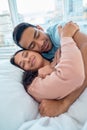 Young mixed race couple lying in bed together and cuddling early in the morning. Handsome asian man holding his Royalty Free Stock Photo