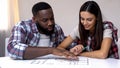 Young mixed-race couple planning interior design of new house, relationship