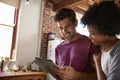 Young mixed race couple using tablet in kitchen, close up