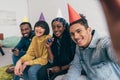 young mixed race doing selfie with multiethnic friends in party