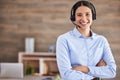 Young mixed race female call center agent standing with her arms crossed wearing a headset answering calls working in an Royalty Free Stock Photo