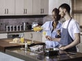Young mixed race happy couple preparing breakfast in the kitchen cooking Royalty Free Stock Photo