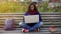 Young mixed race lady writing essay on laptop, studying full of inspiration