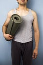 Young mixed race man carrying yoga mat