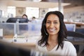 Young mixed race woman in a call centre looking to camera Royalty Free Stock Photo