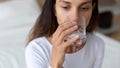 Young mixed race woman drinking glass of fresh pure water.