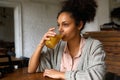 Young mixed race woman drinking orange juice Royalty Free Stock Photo