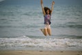 Young mixed race woman jumping on the sea beach. Royalty Free Stock Photo