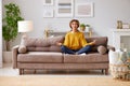 Young mixed race woman meditating with closed eyes  in living room at home Royalty Free Stock Photo