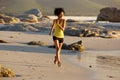 Young mixed race woman running on the beach Royalty Free Stock Photo