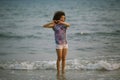 Young mixed race woman walking on the sea beach. Royalty Free Stock Photo