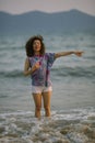 Young mixed race woman walking on the sea beach. Royalty Free Stock Photo