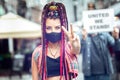 Mixed race woman with face mask showing peace sign during street protest