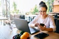 Young mixed race woman working with laptop in cafe at tropical location. Asian caucasian female studying using internet