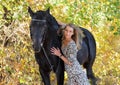 Young equestrian woman walking horse in autumn park Royalty Free Stock Photo