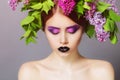 Young model with creative make-up on her face and headdress of floral Royalty Free Stock Photo