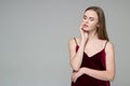 Blond girl in dark red poses showing emotions: wistfulness, dreaminess