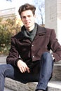 Young model man sitting on marble steps Royalty Free Stock Photo