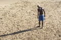 Young model playing sand football on the beach under strong summer sun