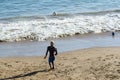 Young model playing sand football on the beach under strong summer sun