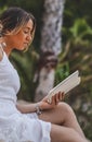 Young model posing in a summer dress and reading a book Royalty Free Stock Photo