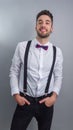 Young model in white shirt, suspenders, bow tie, piercings and fledgling beard Royalty Free Stock Photo