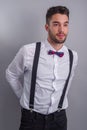 Young model in white shirt, suspenders, bow tie, piercings and fledgling beard Royalty Free Stock Photo