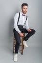 Young model in white shirt, suspenders, bow tie, piercings and fledgling beard Royalty Free Stock Photo