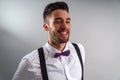 Young model in white shirt, suspenders, bow tie, piercings and fledgling beard Royalty Free Stock Photo
