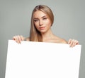 Young model woman with clear skin holding empty white card singboard Royalty Free Stock Photo