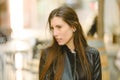 Young model woman with long straight hair wearing leather jacket posing carefree and casual on the street