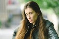 Young model woman with long straight hair wearing leather jacket posing carefree and casual on the street